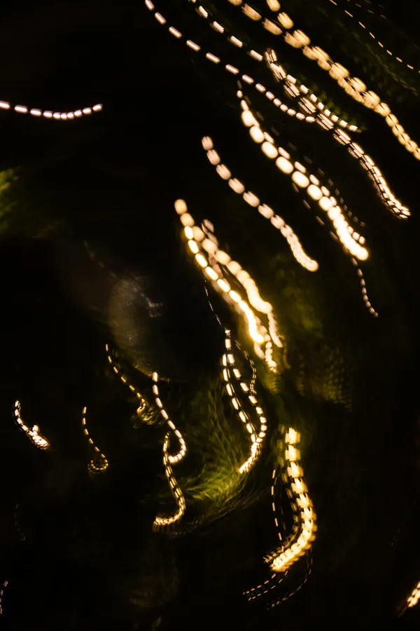 Christmas lights dance through the darkness, their paths traced by intentional camera movement.
