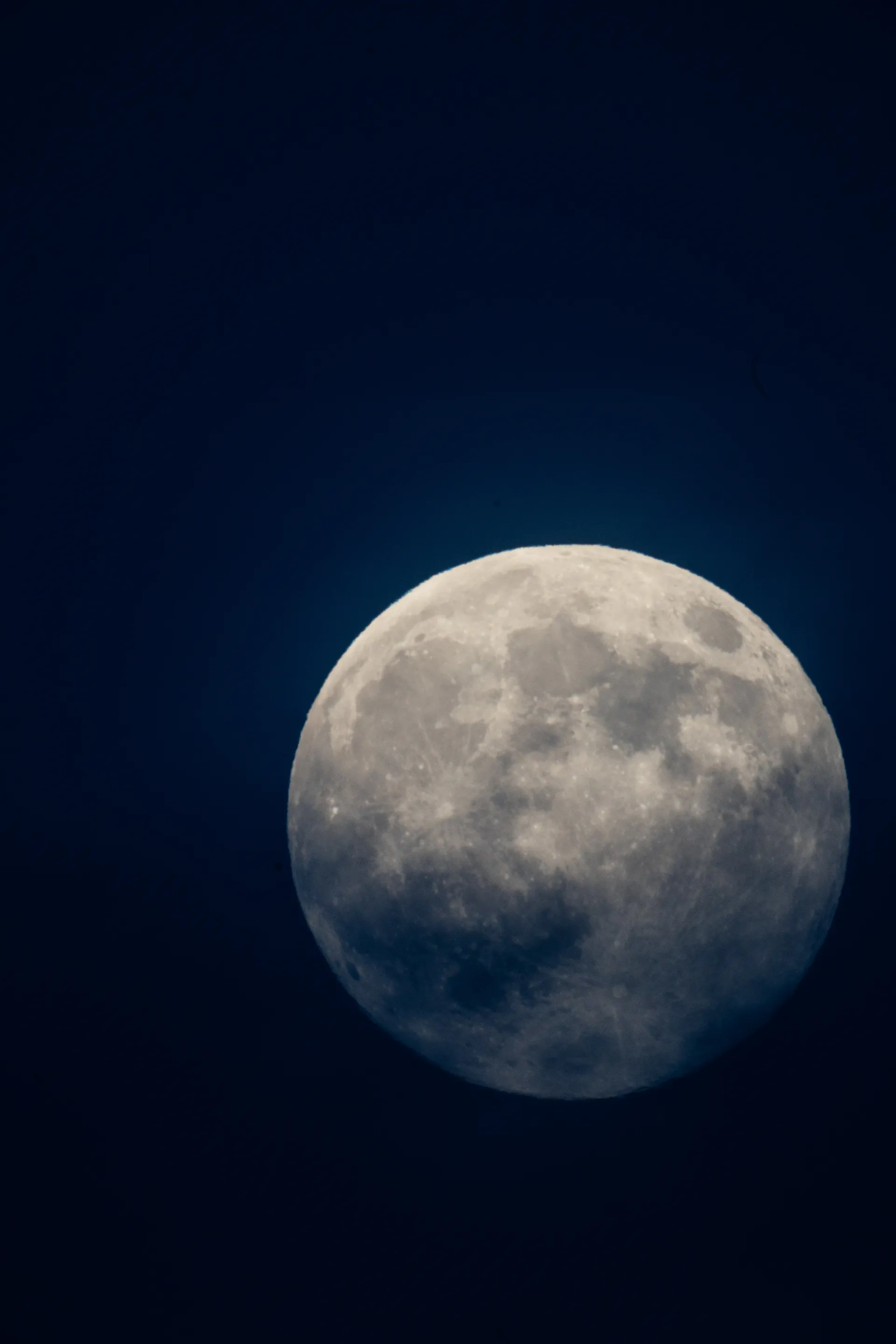 A close-up view of the moon reveals the textured surface of craters and ancient lava plains.
