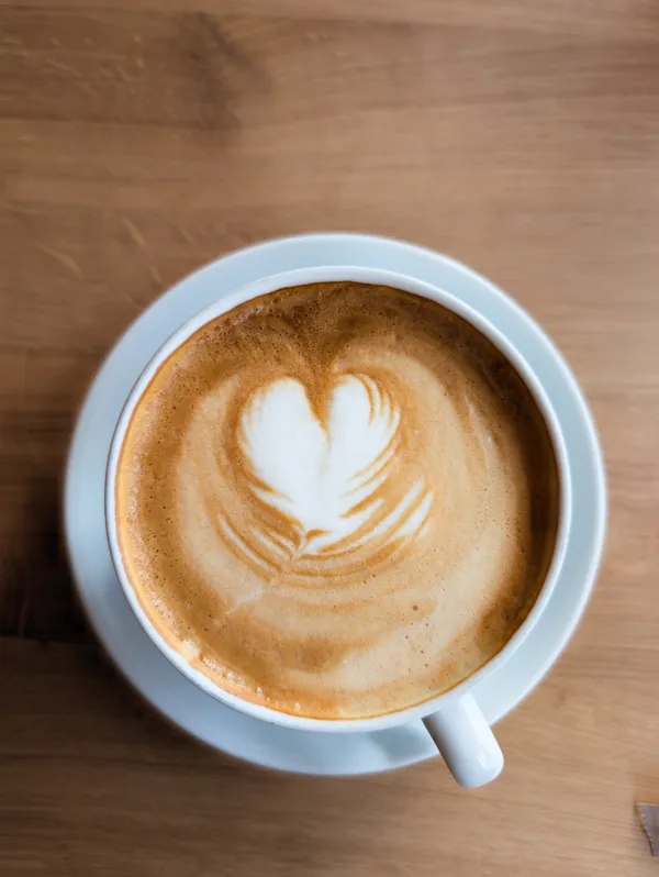 A perfectly poured heart in creamy milk foam atop a warm coffee.