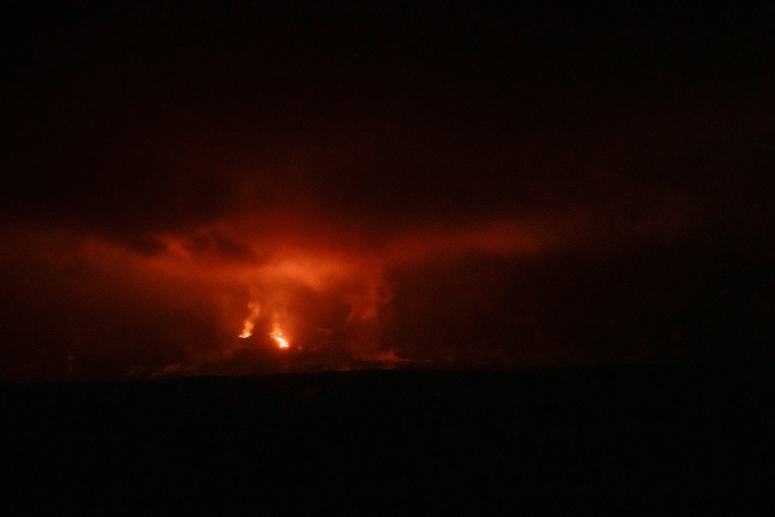 An active eruption lights up the night sky from miles away.