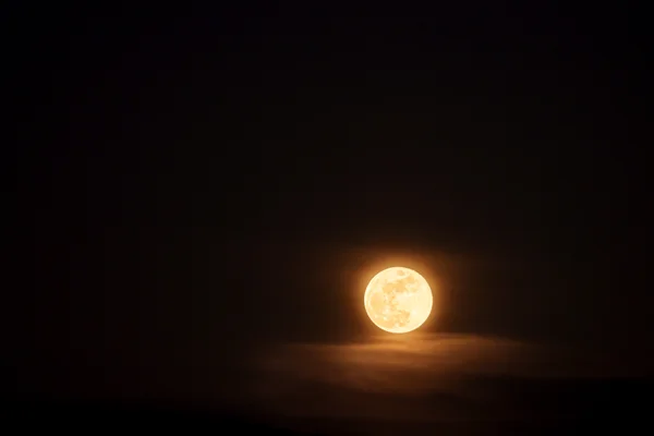 A full moon emerges through soft clouds over Mythenquai, glowing warm against the dark sky.